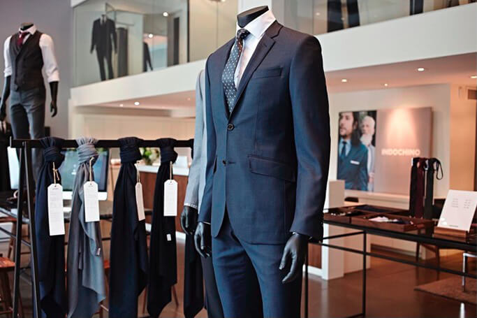 A navy suit on display in an INDOCHINO showroom.